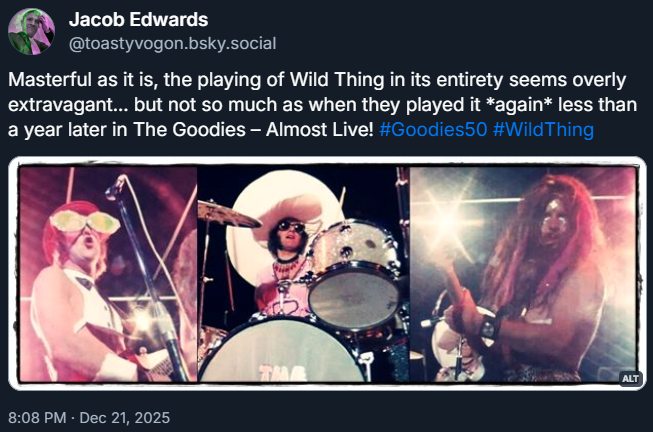 Tim and Bill playing guitars; Graeme on drums. All are dressed in outrageous rock getup.